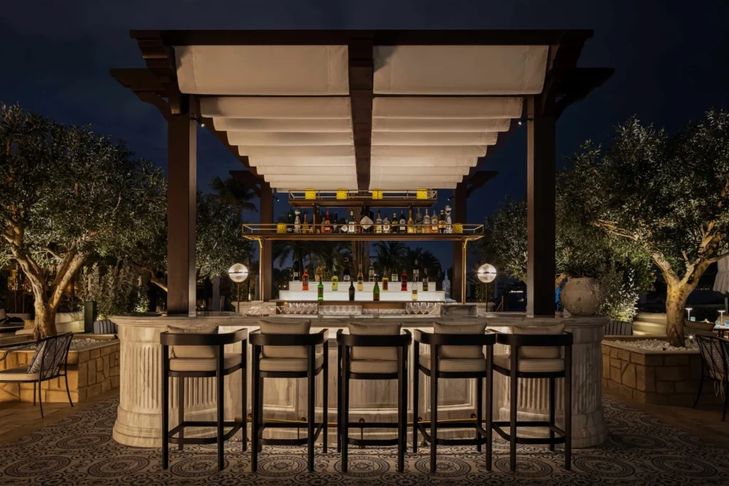 Olive tree UAE graces a seaside dining area; high-quality artificial olive trees Dubai create a chic Mediterranean vibe.