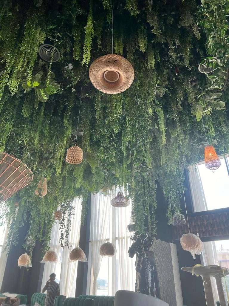 ush green artificial wall with tropical faux plants and pink flowers in an indoor UAE space