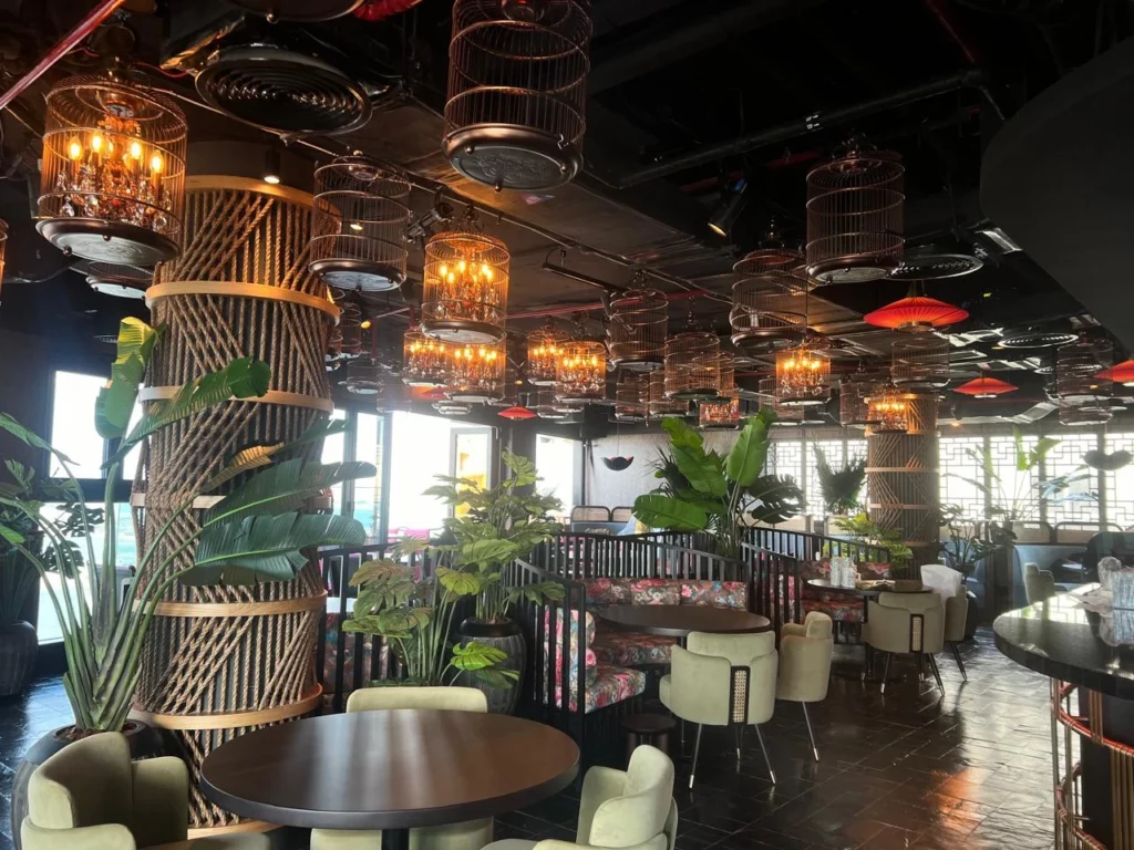Stylish dining area accented with luxury fake plants KSA from leading artificial plant wholesalers in Saudi Arabia.