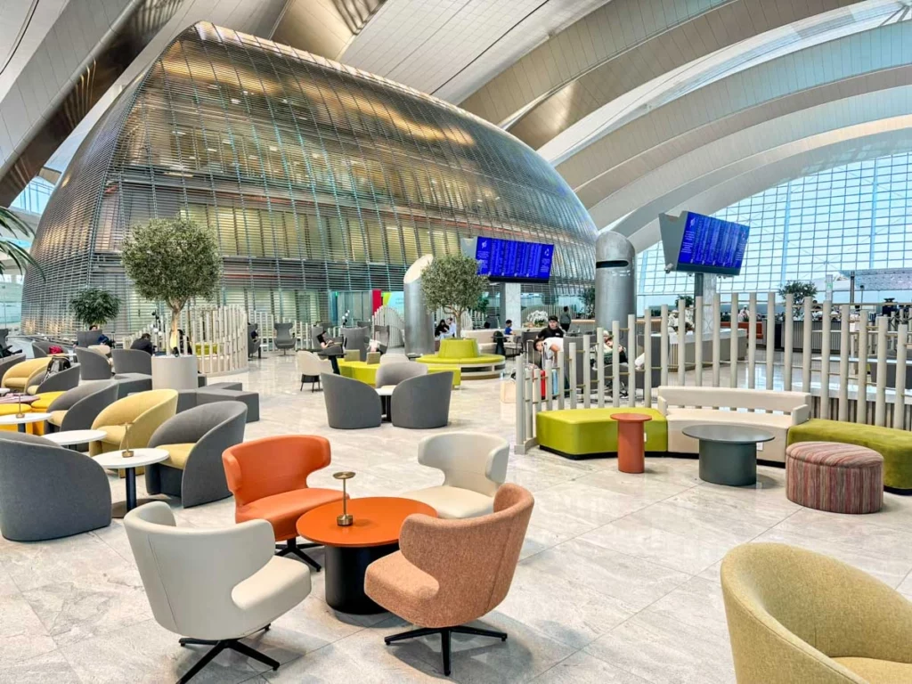 Modern indoor lounge setting with artificial trees in white planters at Dubai Airport, supplied by artificial plant suppliers UAE